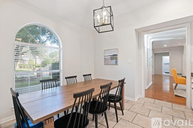 A dining room with a wooden table and chairs.