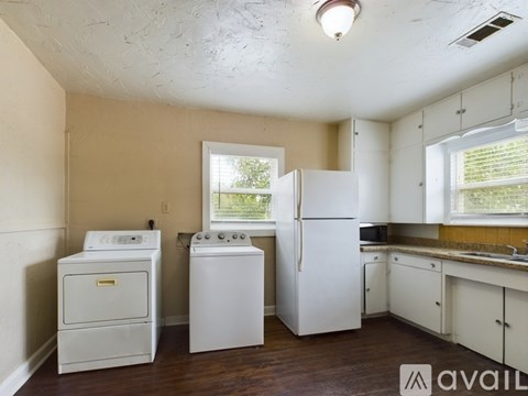 A kitchen with a white fridge, white oven, and white washer.