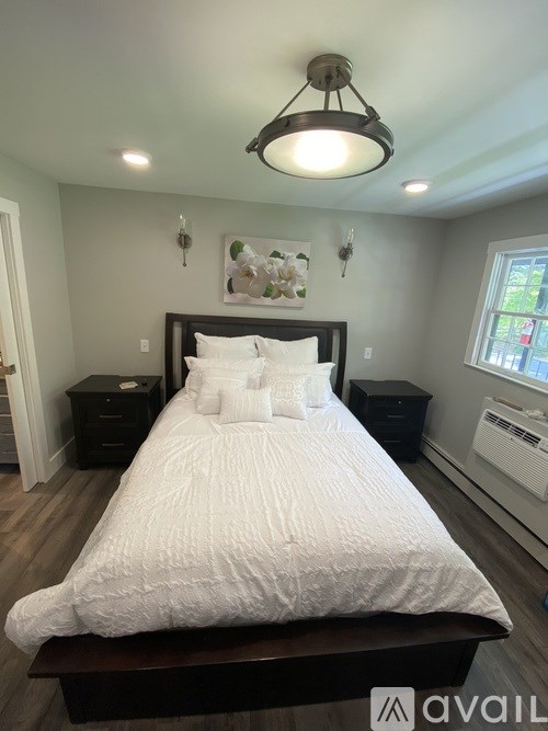 A bedroom with a large bed and a window.