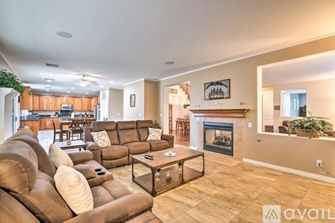 A living room with a brown couch and a fireplace.