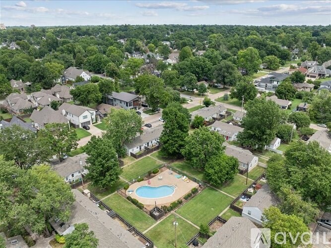 A bird's eye view of a neighborhood with a swimming pool in the center.
