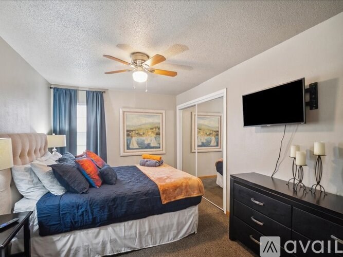 A bedroom with a bed, dresser, and television.