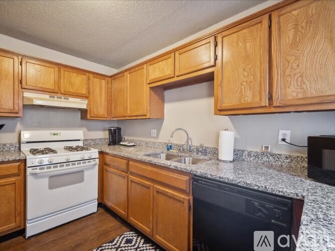 A kitchen with wooden cabinets and a white stove top oven.