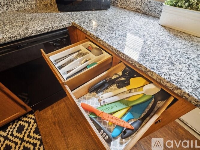 A drawer full of colorful knives and utensils.