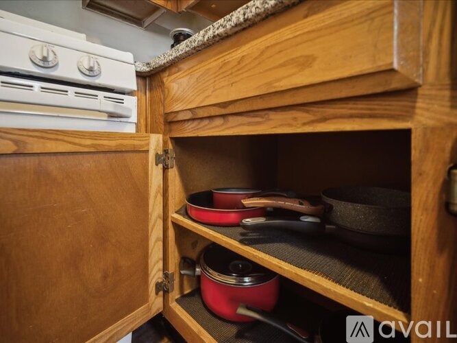 A kitchen cabinet with a variety of pots and pans.