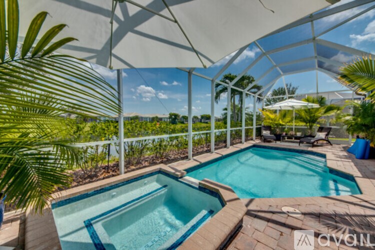 A pool area with a white canopy and a blue pool.