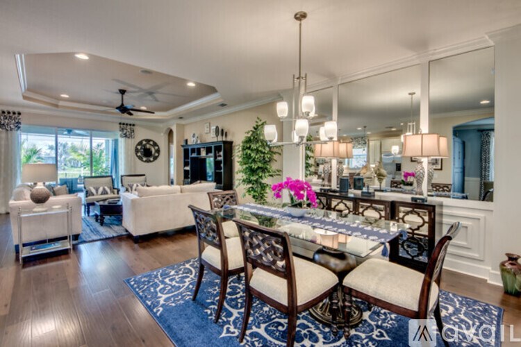 A dining room with a table set for two and a couch.