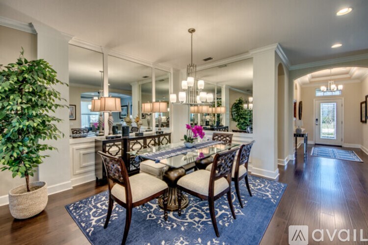 A dining room with a large table and chairs.
