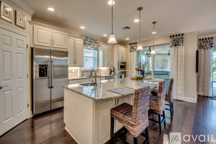A kitchen with a refrigerator, sink, and dining table.
