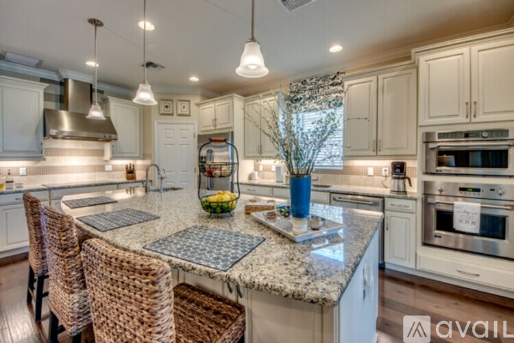 A kitchen with a granite countertop and stainless steel appliances.