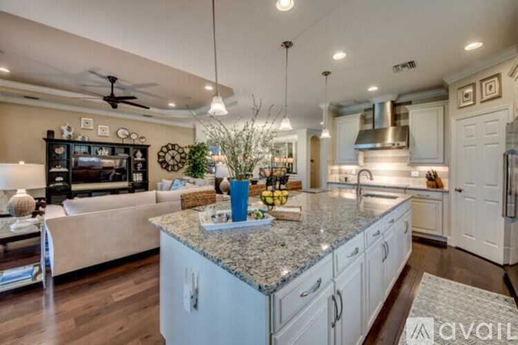 A kitchen with a granite countertop and white cabinets.