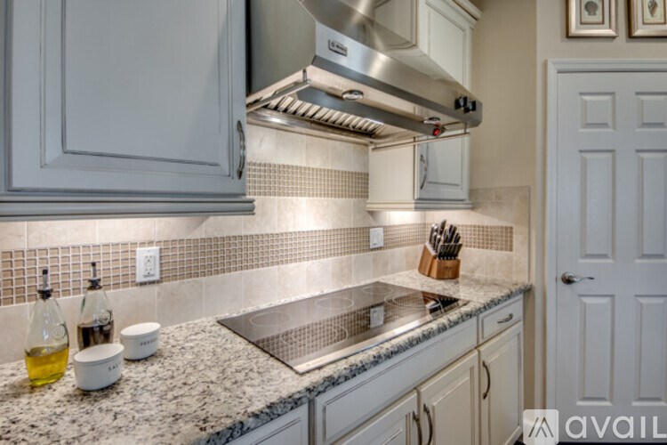 A kitchen with a granite countertop and a stainless steel range hood.