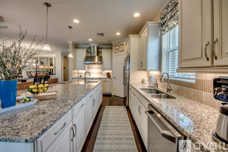 A kitchen with granite countertops and white cabinets.