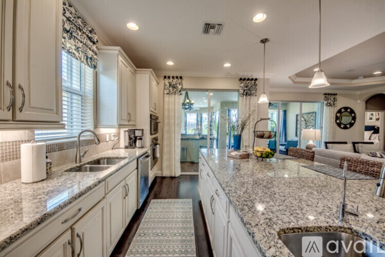 A kitchen with granite countertops and white cabinets.