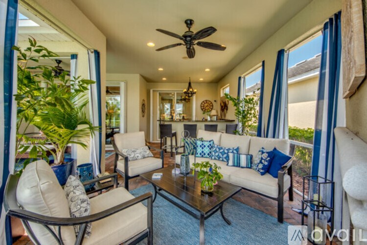 A living room with a white couch and a glass coffee table.