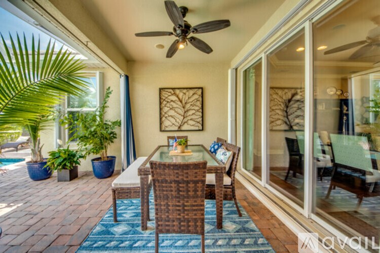 A patio with a table and chairs and a ceiling fan.