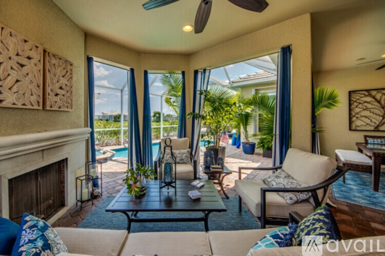 A living room with a fireplace and a view of the pool.