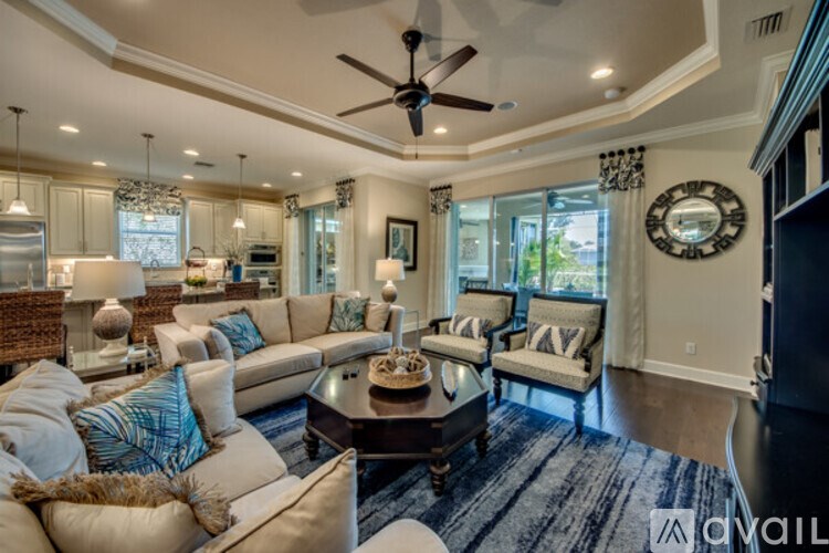 A living room with a white couch and a blue rug.
