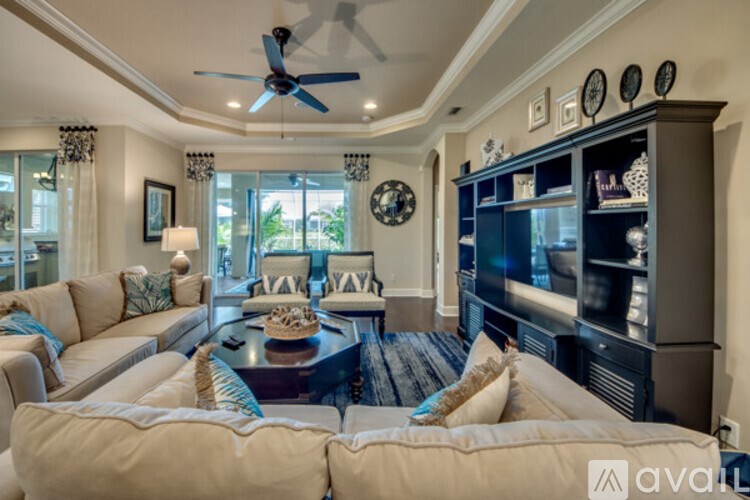 A living room with a white couch and a dark wood coffee table.
