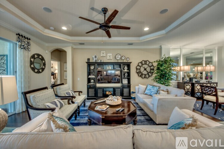 A living room with a white couch, a wooden coffee table, and a ceiling fan.