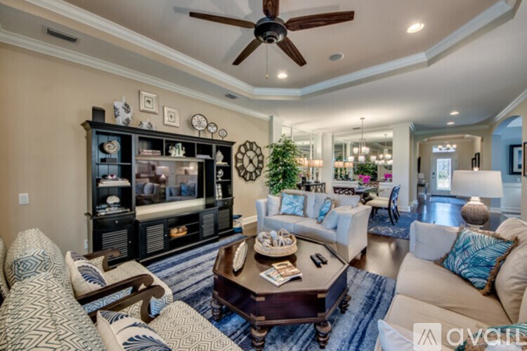 A living room with a ceiling fan and a large entertainment center.