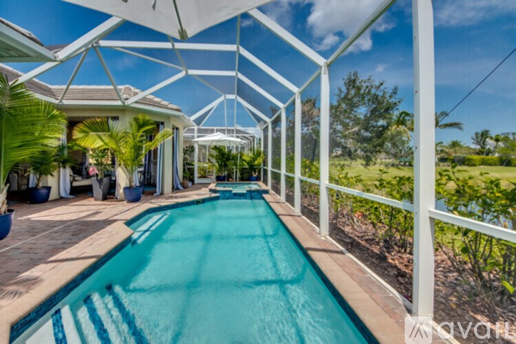 A long rectangular pool with a white fence surrounding it.