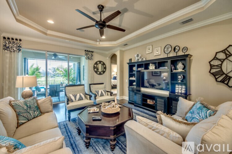 A living room with a ceiling fan and a flat screen TV.