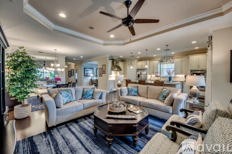 A living room with a large couch and a ceiling fan.