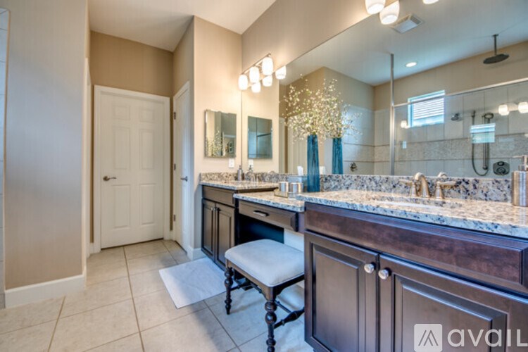 A bathroom with a vanity, mirror, and a white door.