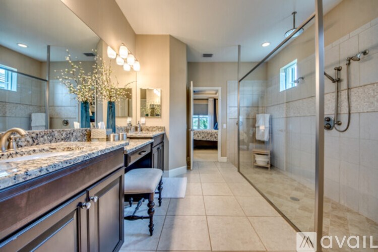 A bathroom with a vanity, a mirror, and a shower.