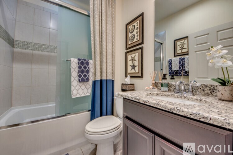 A bathroom with a toilet, sink, and shower.
