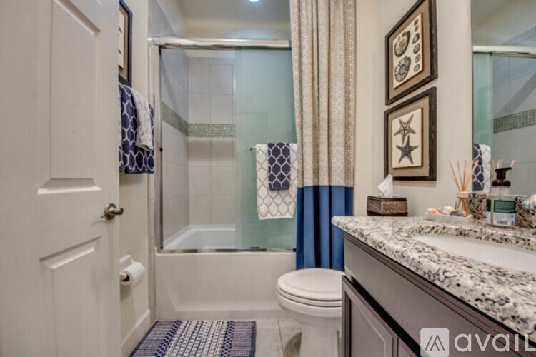 A bathroom with a toilet, sink, and shower.
