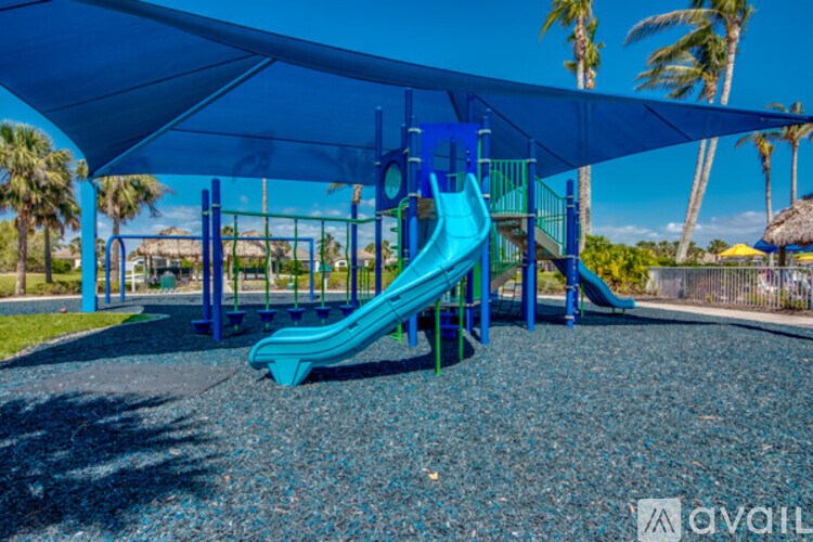 A playground with a blue slide and a blue canopy.