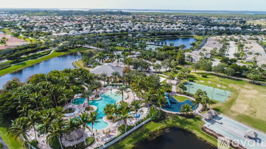 An aerial view of a resort with a swimming pool and palm trees.
