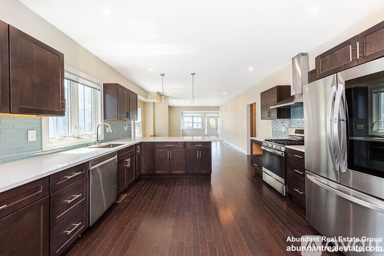 A spacious kitchen with dark wood floors and stainless steel appliances.