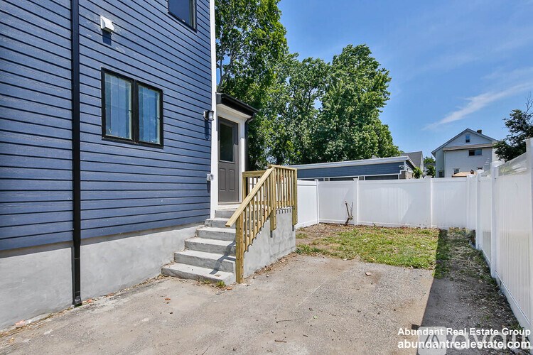 A blue house with a white fence and a small garden.