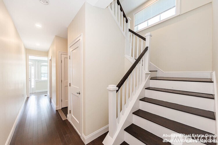 A spacious hallway with a staircase leading to the second floor.