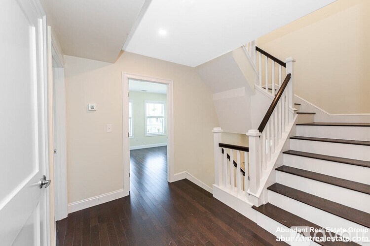A spacious hallway with a staircase leading to the second floor.