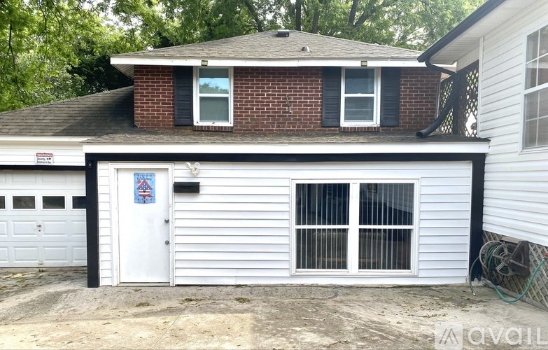 A house with a white garage door and a red brick chimney.