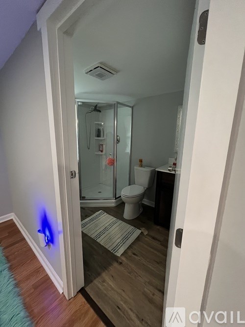 A bathroom with a toilet, sink, and mirror.