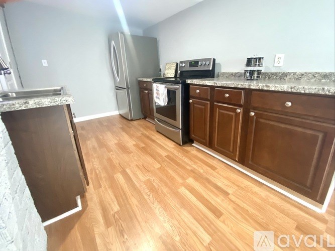 A kitchen with wooden floors and a granite countertop.