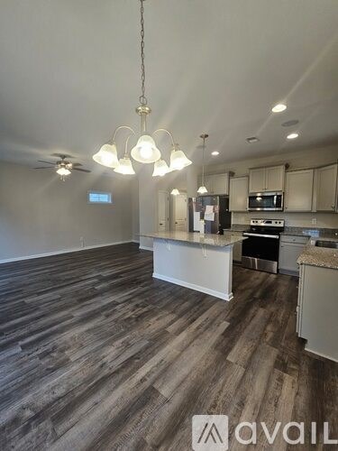 A kitchen with a white counter and wooden flooring.