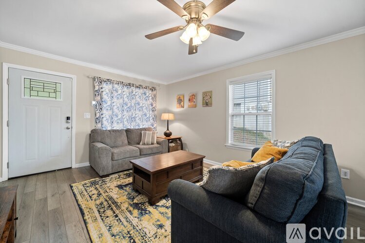 A living room with a grey couch and a wooden coffee table.