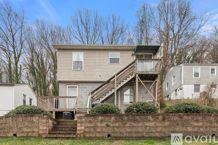 A two-story house with a deck and a garage is for sale.