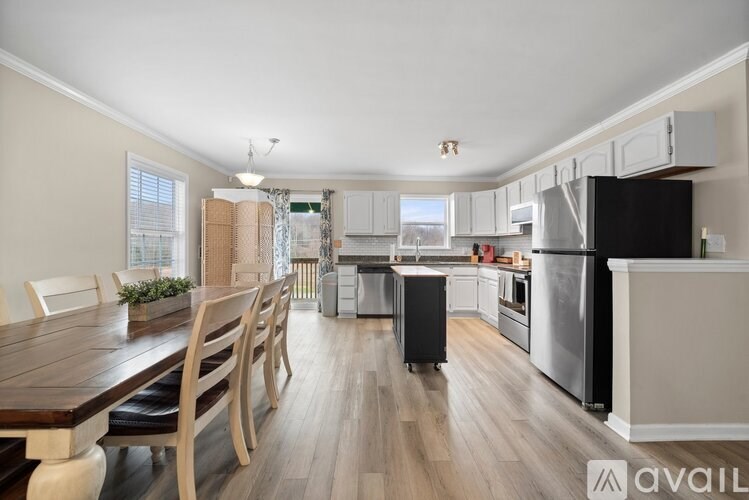 A kitchen with a wooden table and chairs is available for rent.