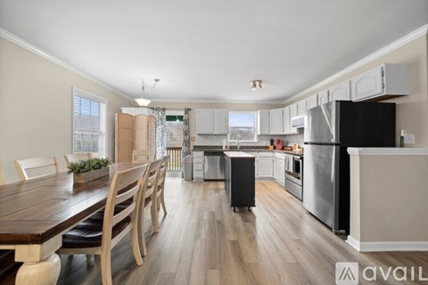 A kitchen with a wooden table and chairs is available for rent.