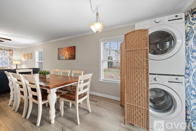 A dining room with a wooden table and chairs.