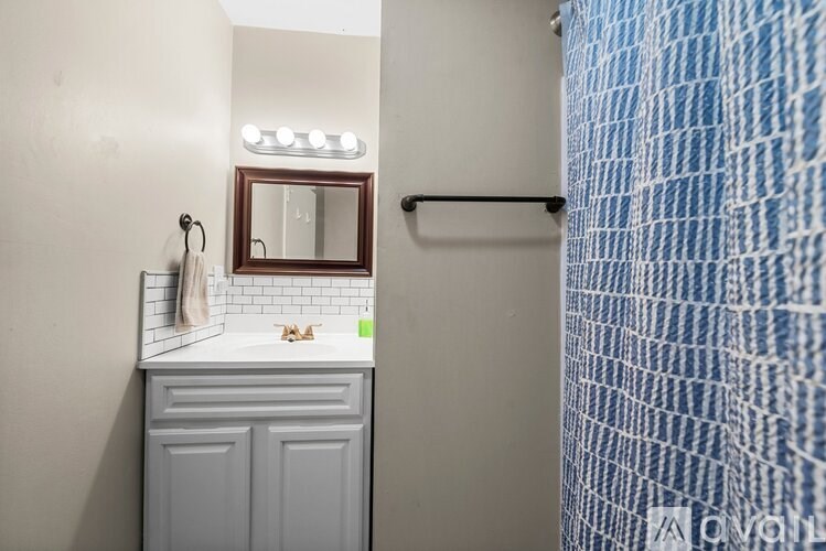A bathroom with a white sink and a mirror above it.