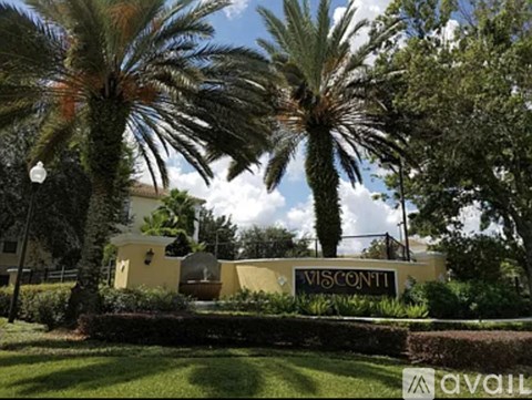 A building with the word "VISCONTI" on it is surrounded by palm trees.