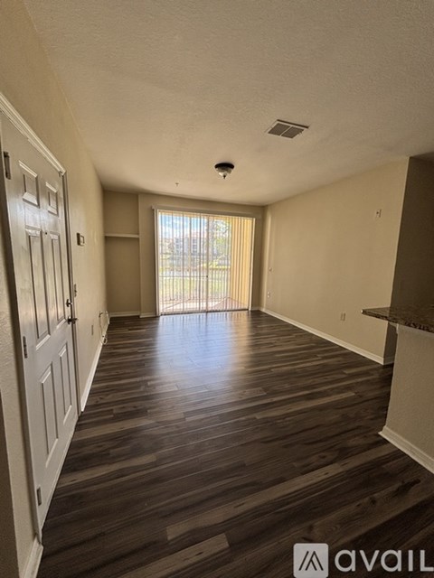 A long hallway with wood floors and white walls.